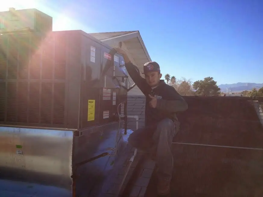 HVAC technician performing Air Duct Repair on a rooftop unit in Larkin
